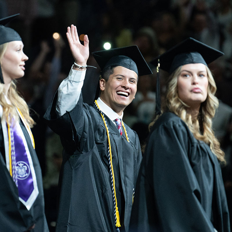 Alumni waving at graduation