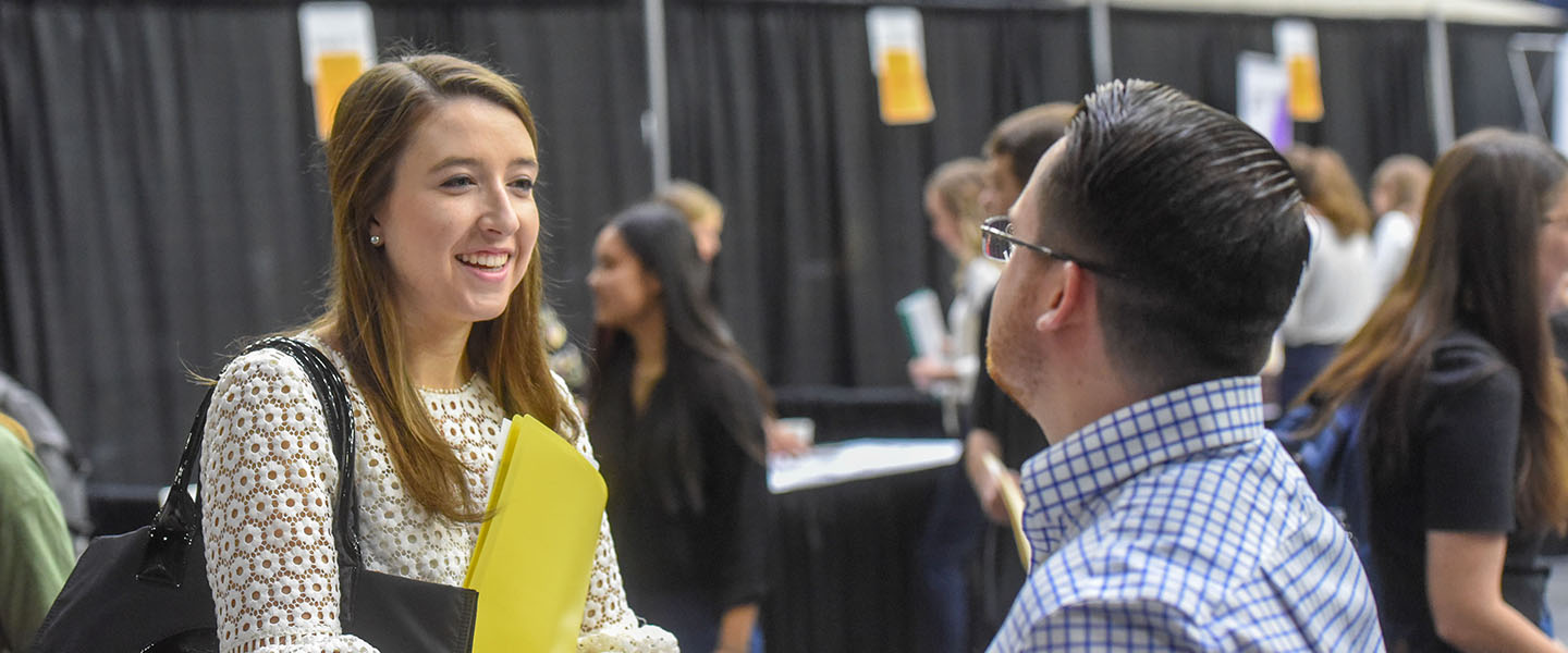 A student talking with an employer at a job fair