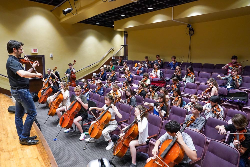 Summer camp students participate strings class