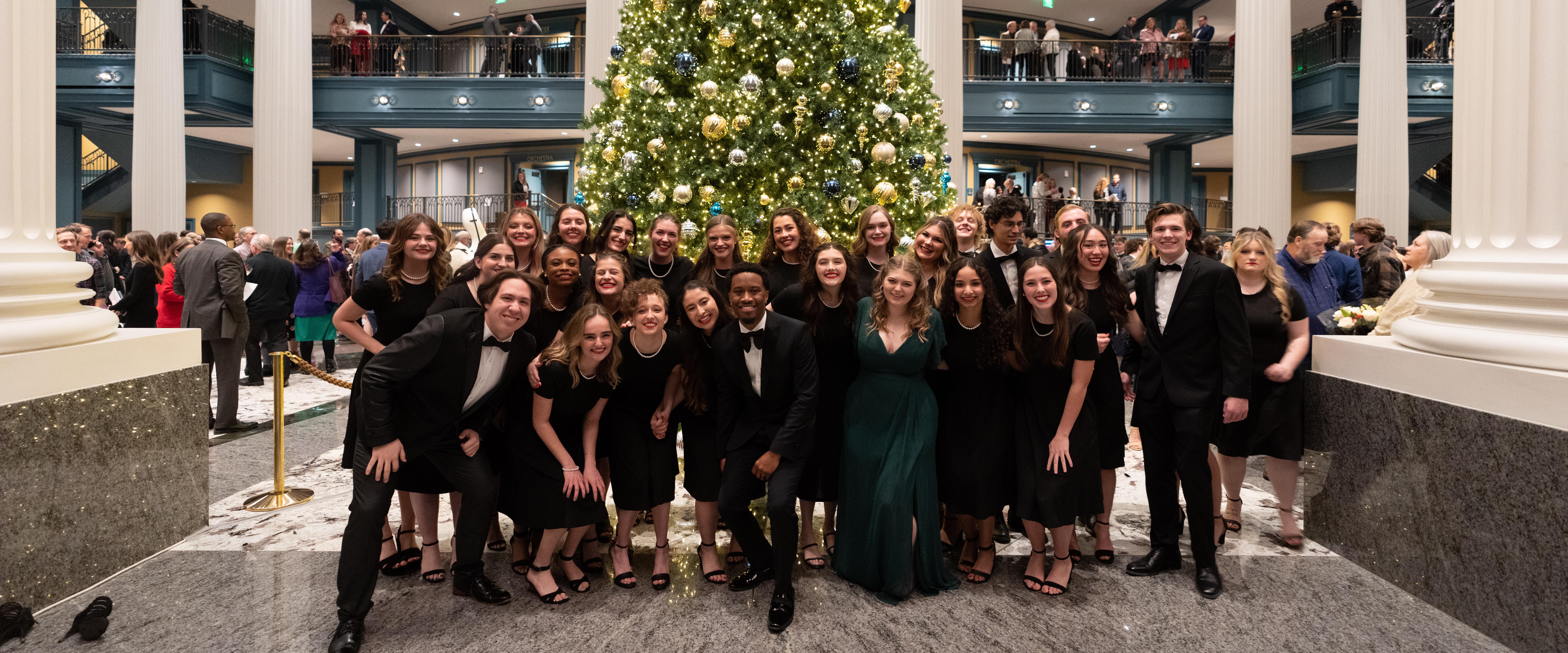 Belmont Choir posing for picture in the fisher center lobby at Christmas time