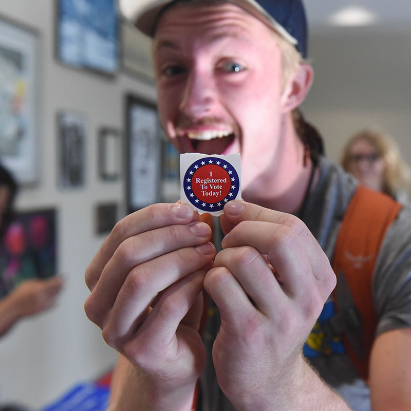 Student holding an I Voted Sticker
