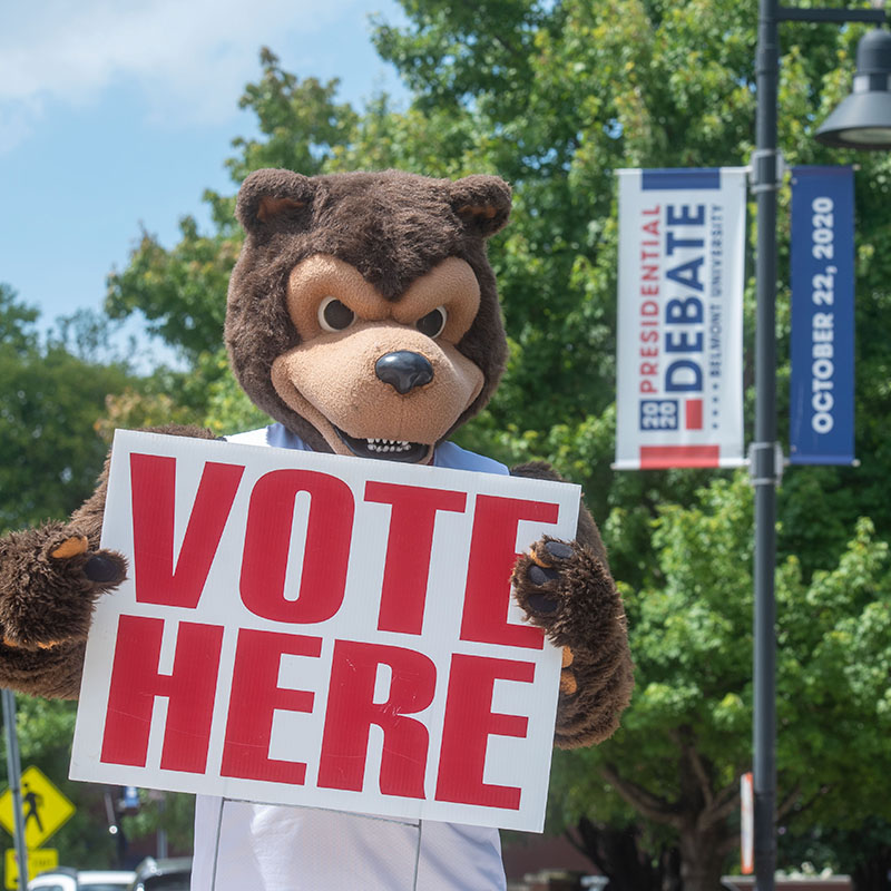 Bruiser holding a Vote Here Sign