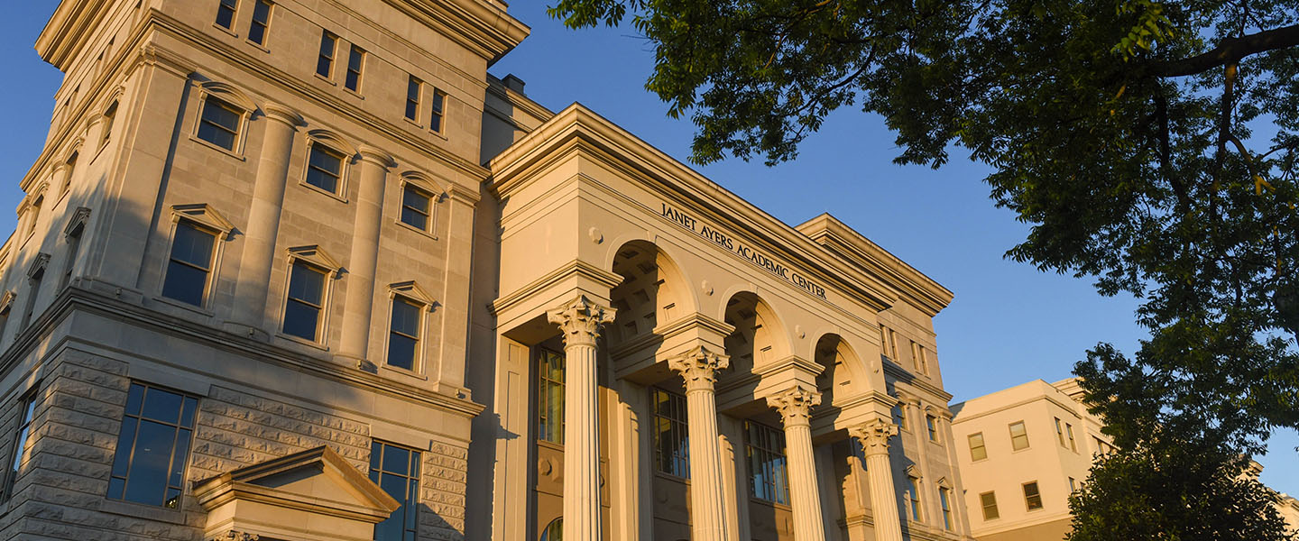 A view of the front of the Ayers Academic Center at sunrise