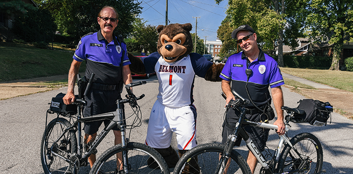 Officers on bicycles posing with Bruiser