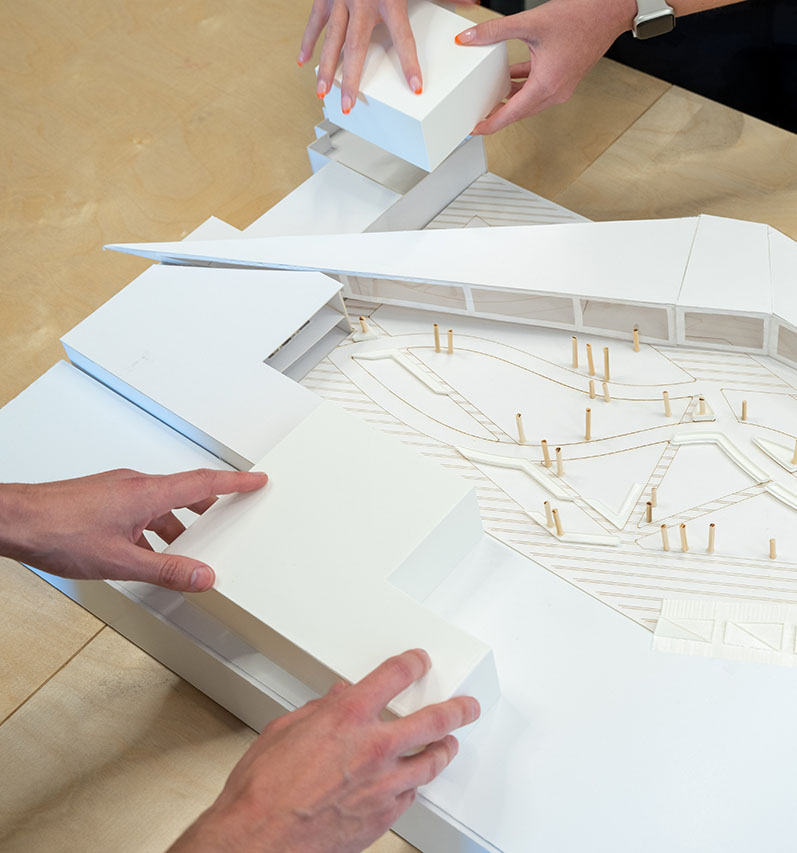 The hands of two students working on an architectural model