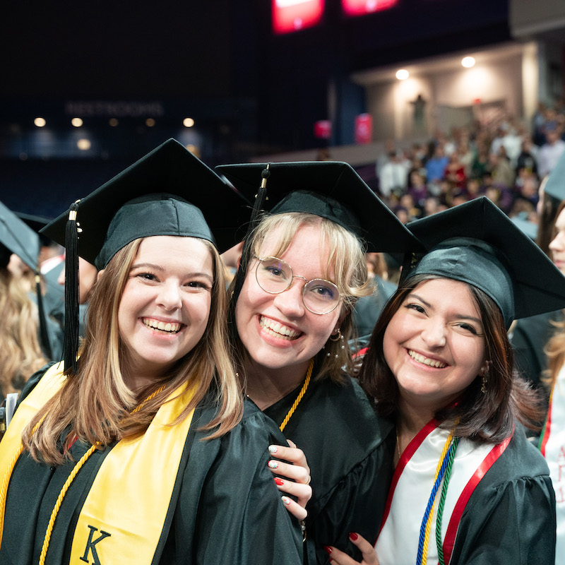 Three graduates at commencement