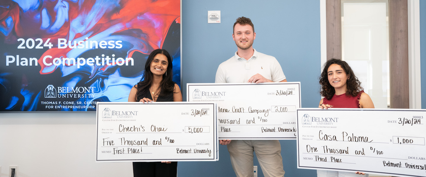 Winners of Business Pitch Competition pose with giant checks