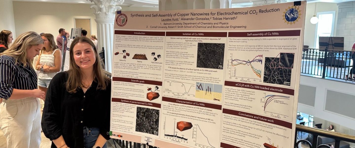 Lauralee Hurst poses with her project research from Cornell