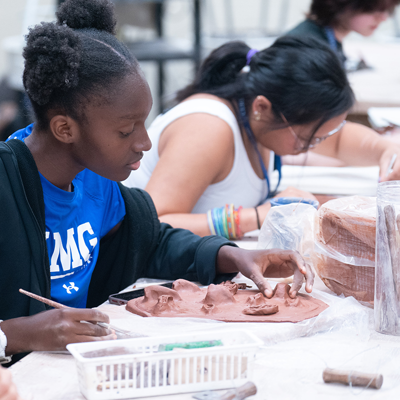 Student working on a clay sculpture
