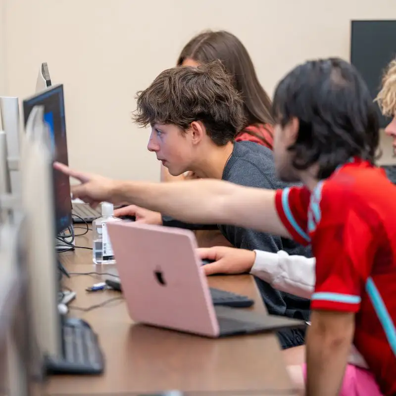 Parra Rodriguez instructs students at game design camp on computers