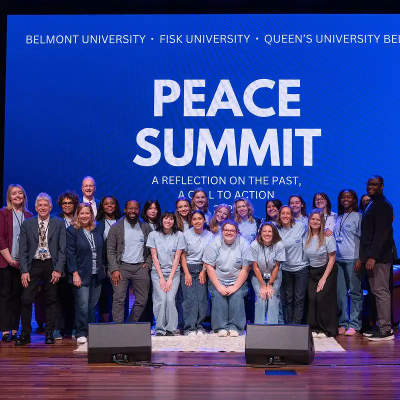 Peace Summit committee and volunteers in front of a screen reading “Peace Summit”