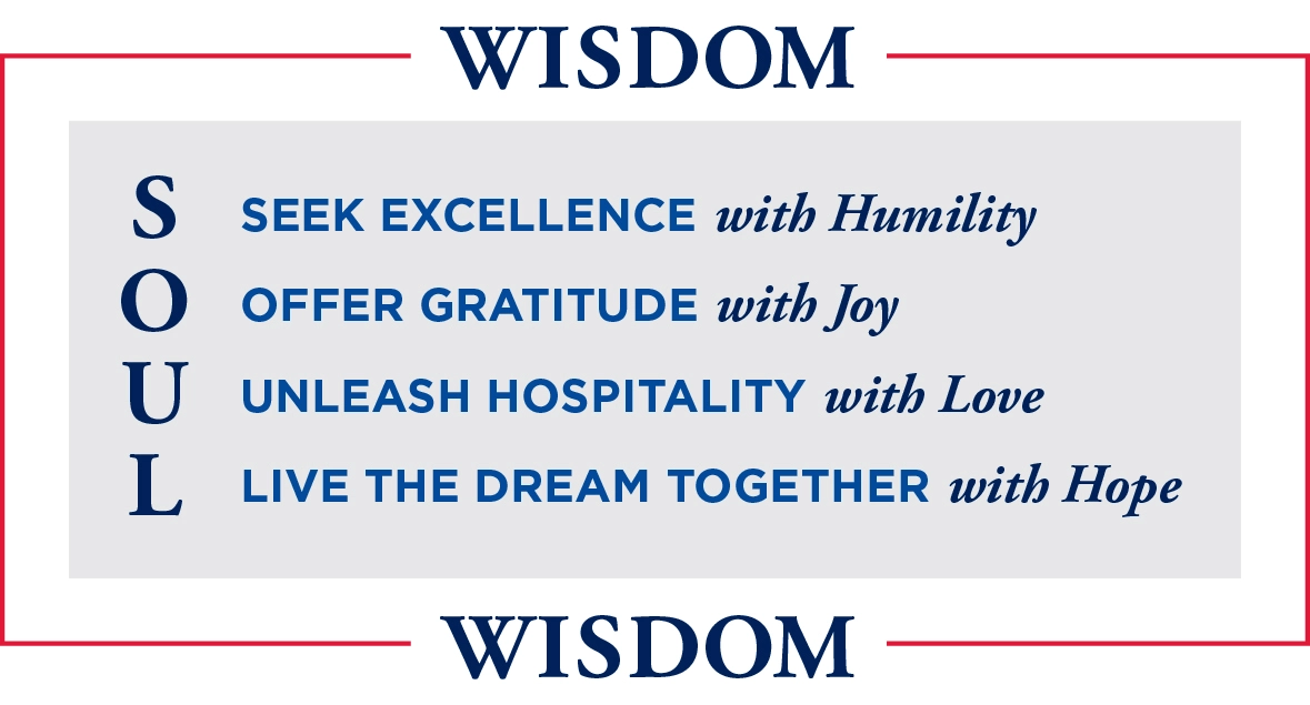 An image with the word "WISDOM" at the top and bottom in bold gold text. In between, the acronym "SOUL" is displayed vertically with each letter standing for a value: S - Seek Excellence O - Offer Gratitude U - Unleash Hospitality L - Live the Dream Together