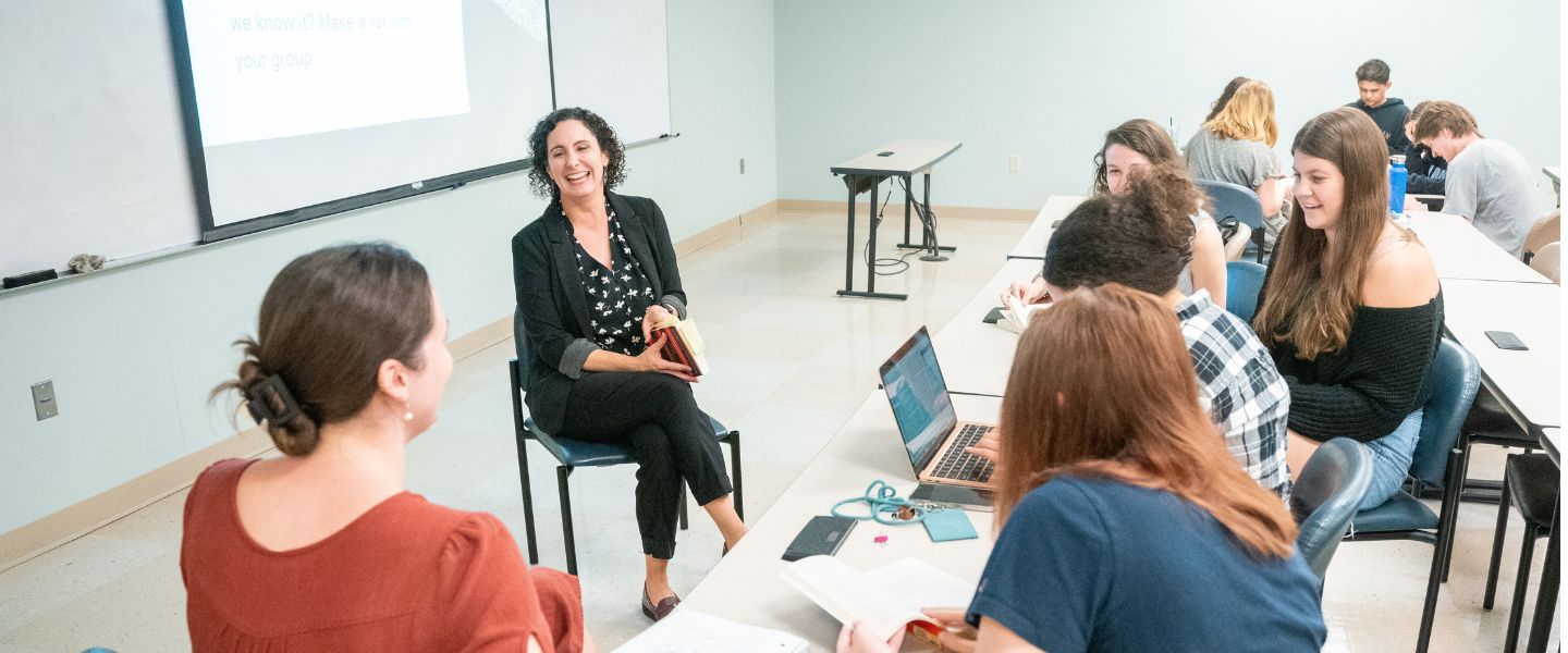 Professor discusses a book with students