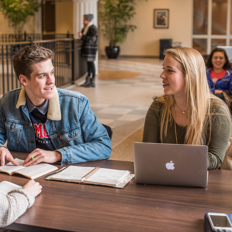 Two students having a discussion at a study table in the JAAC
