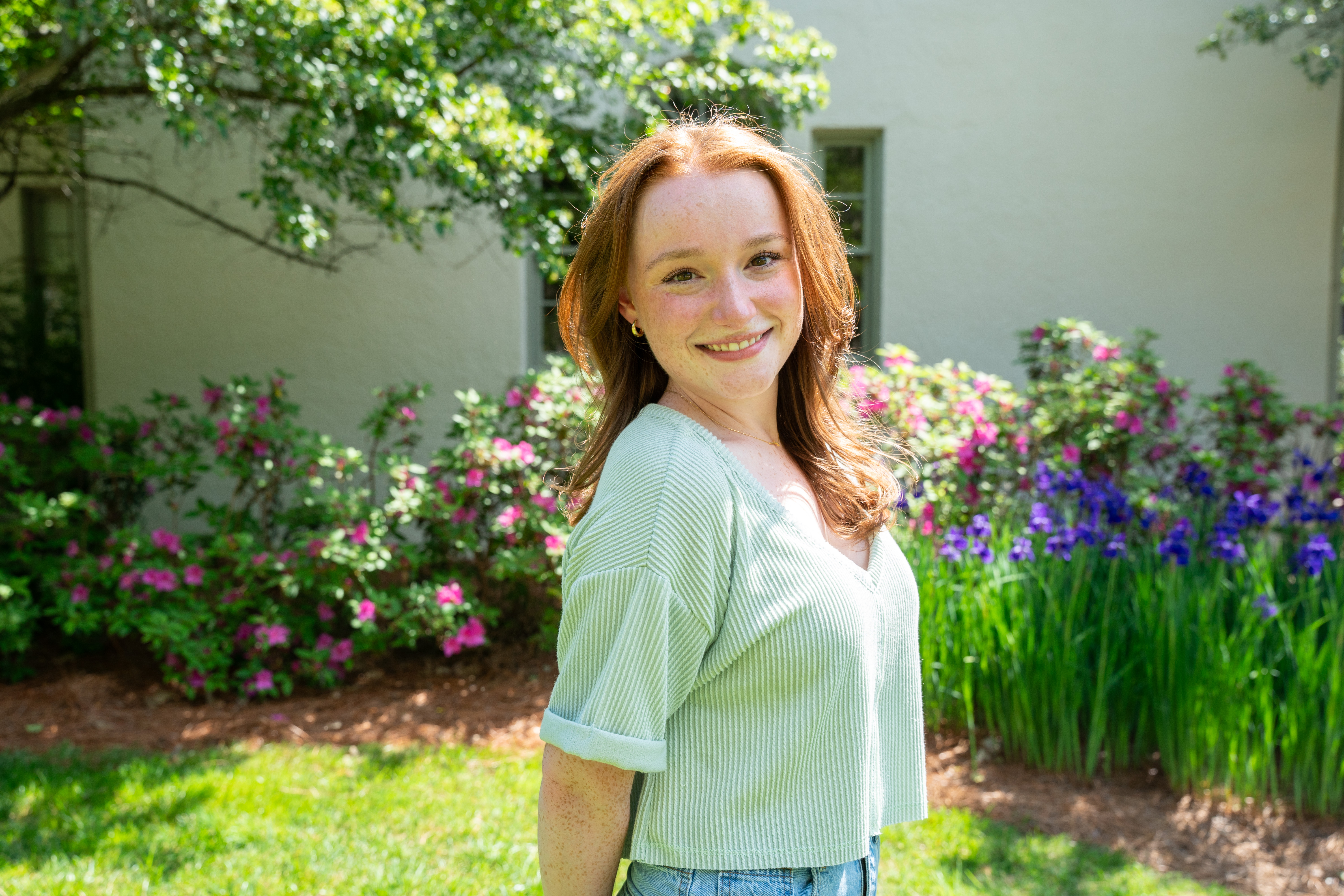 Erin Radigan posing in front of spring flowers on Belmont's campus