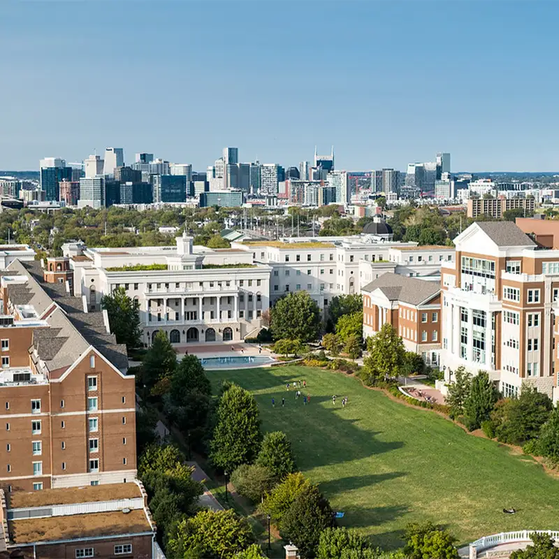 An outdoor aerial photo of Belmont's campus in the foreground with Nashville's city skyline in the background