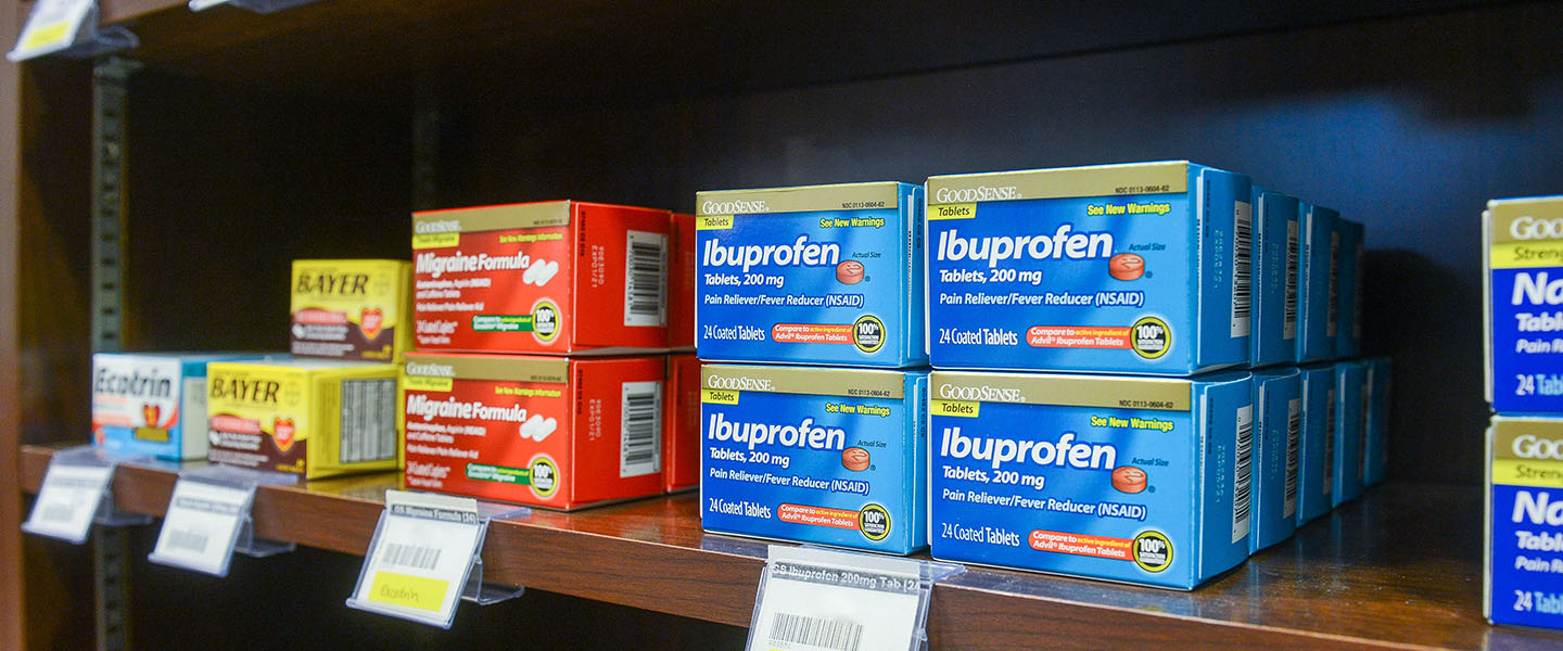 A shelf in the campus pharmacy showing over the counter products like ibuprofen