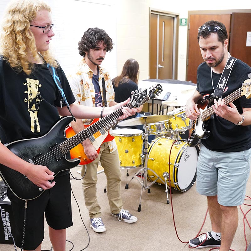 Guitar professor teaches guitar to students