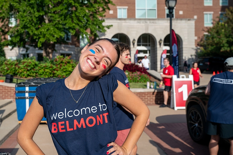 An image of a Belmont student with a Welcome to Belmont t-shirt on and red and blue face paint