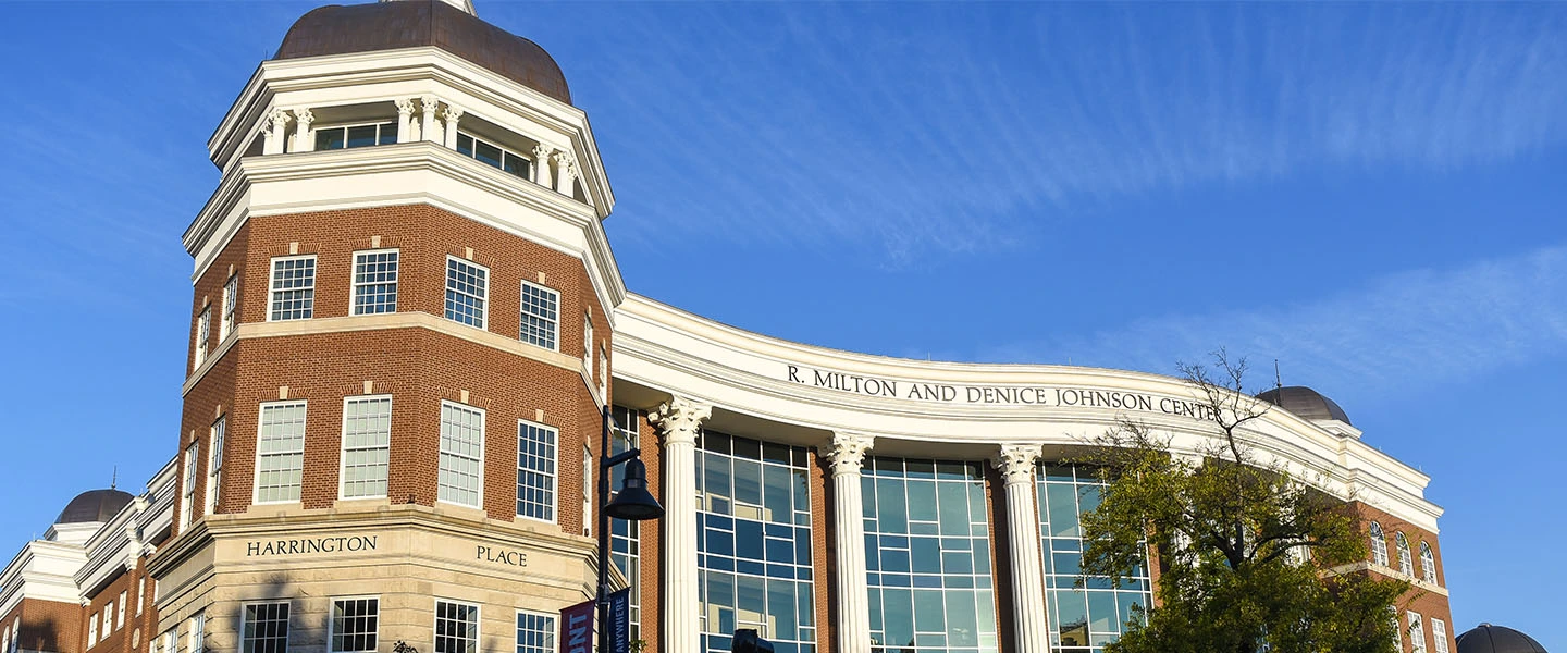 An outdoor photo of the front of the Johnson Center during the morning golden hour