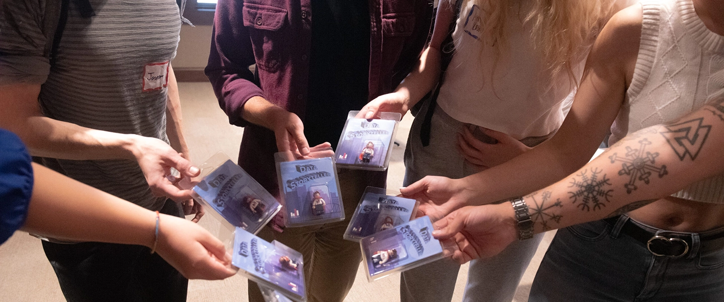 Students displaying their hands holding their nametags for a data event