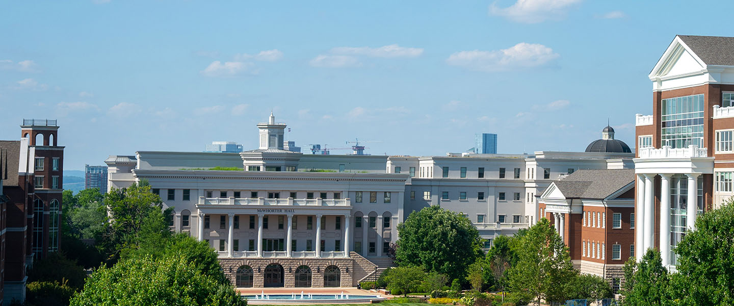 A photo of Belmont's lawn with the Nashville skyline in the background