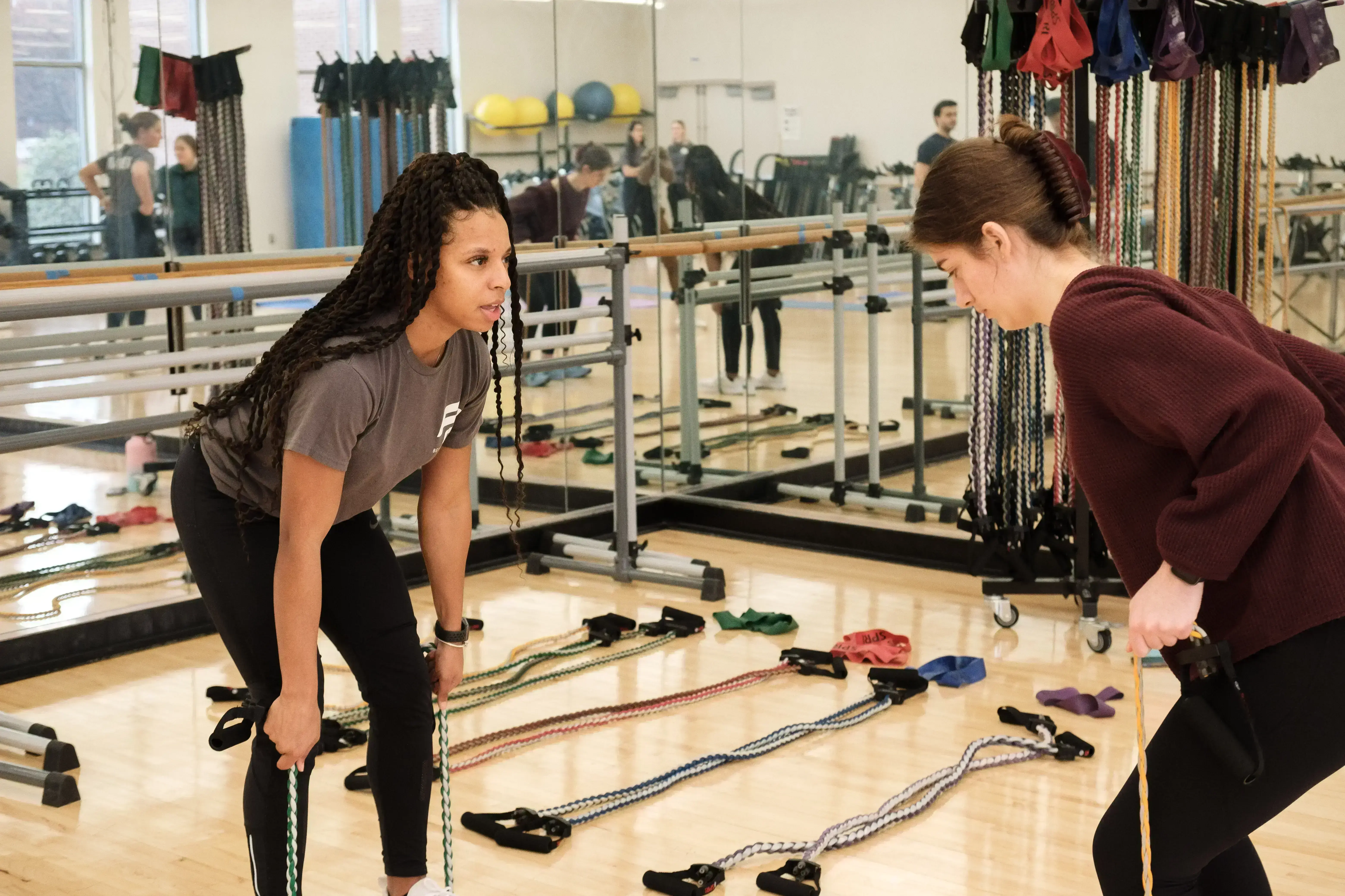 An indoor photo of a female training giving personal training to another female