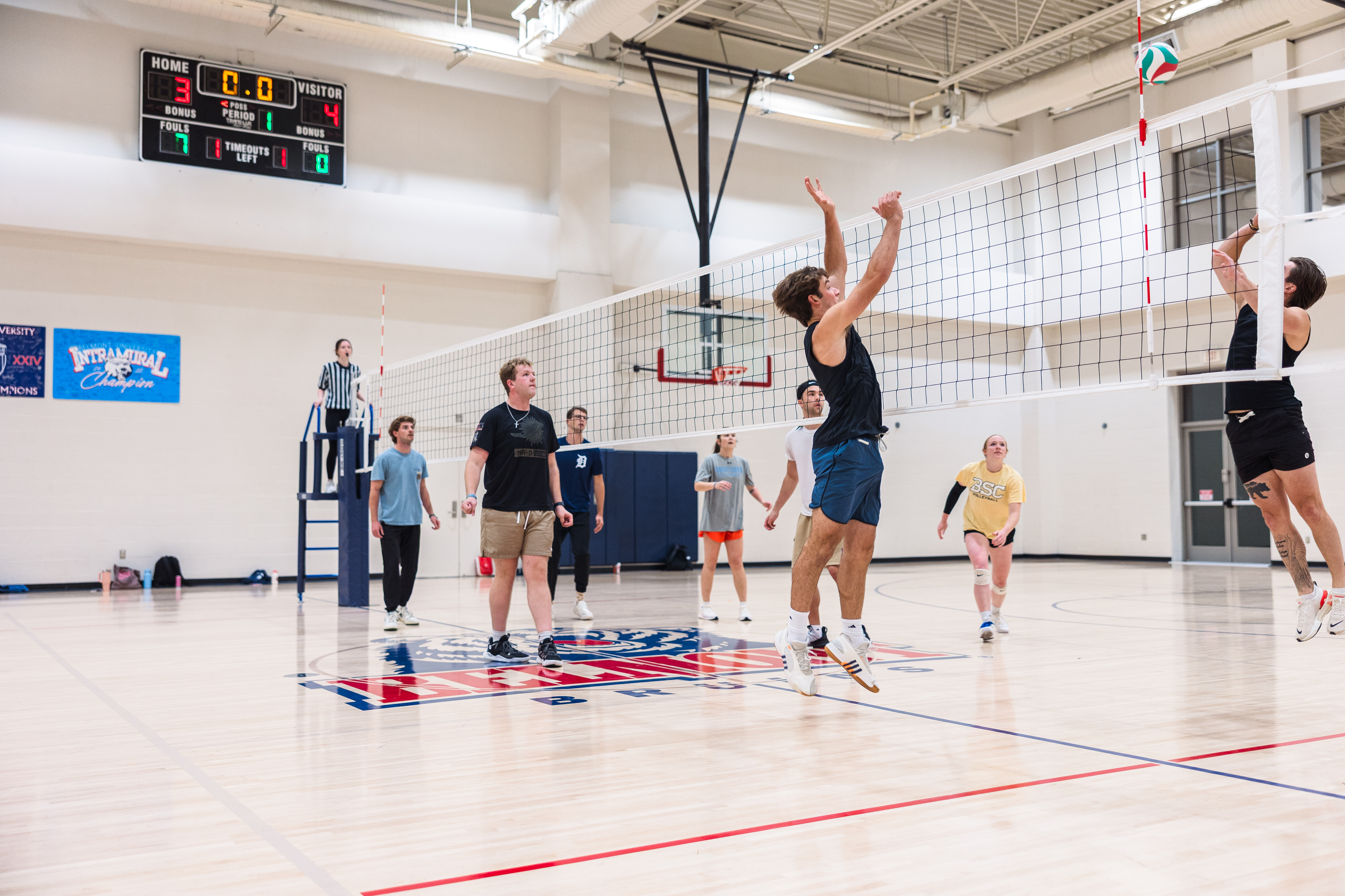 Student climbing the rock wall with a smile