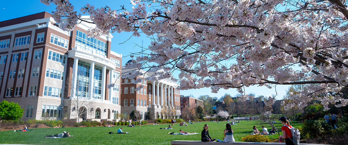 View of the Jack C Massey center from the lan with students enjoying the nice weather