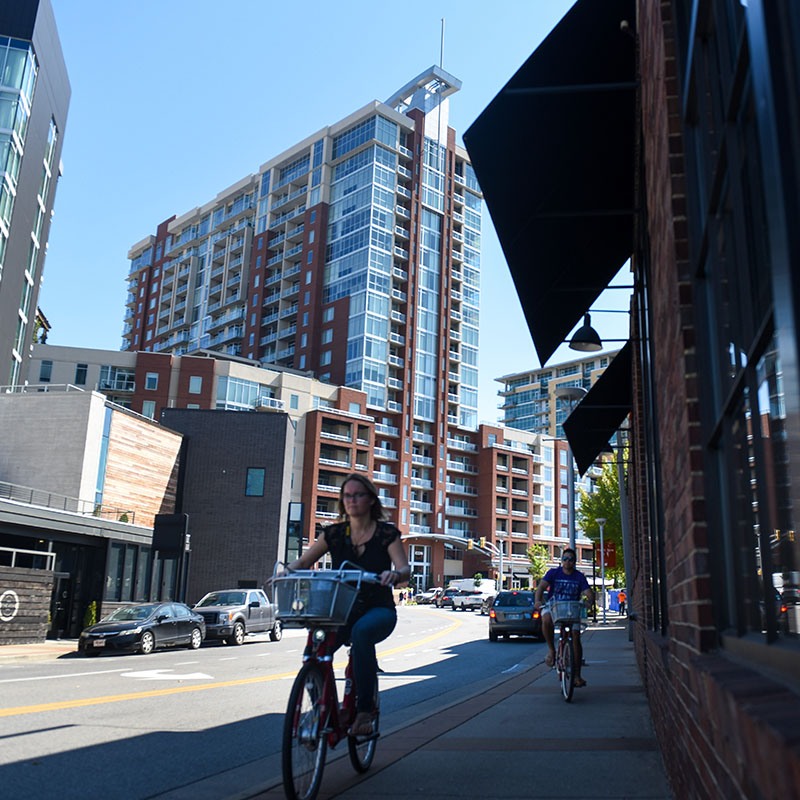 A student riding a bicycle through the Gulch