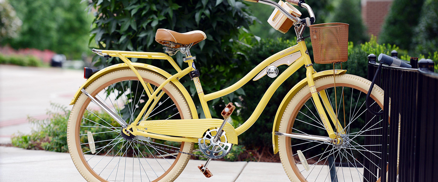 A yellow bicycle parked on a sidewalk