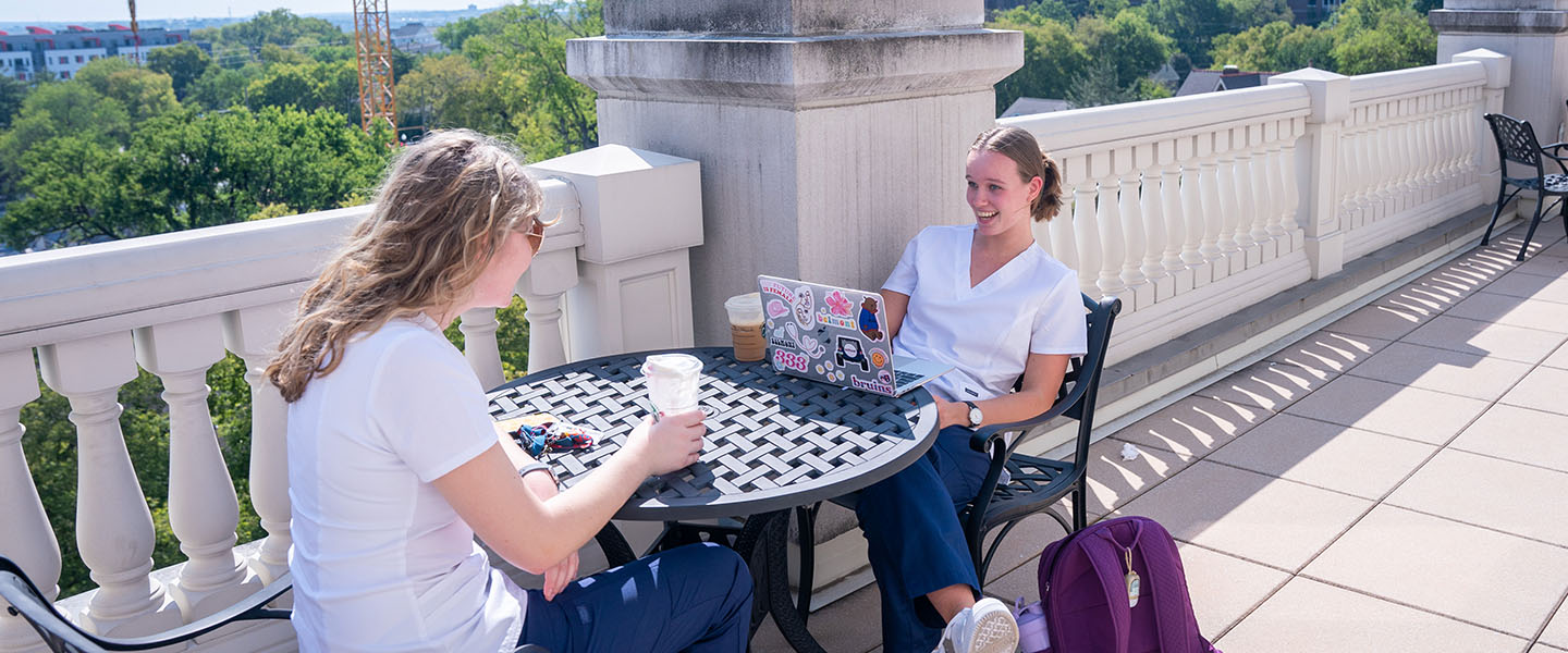 Two nursing students having coffee together on the 4th Floor Ayers Center Patio