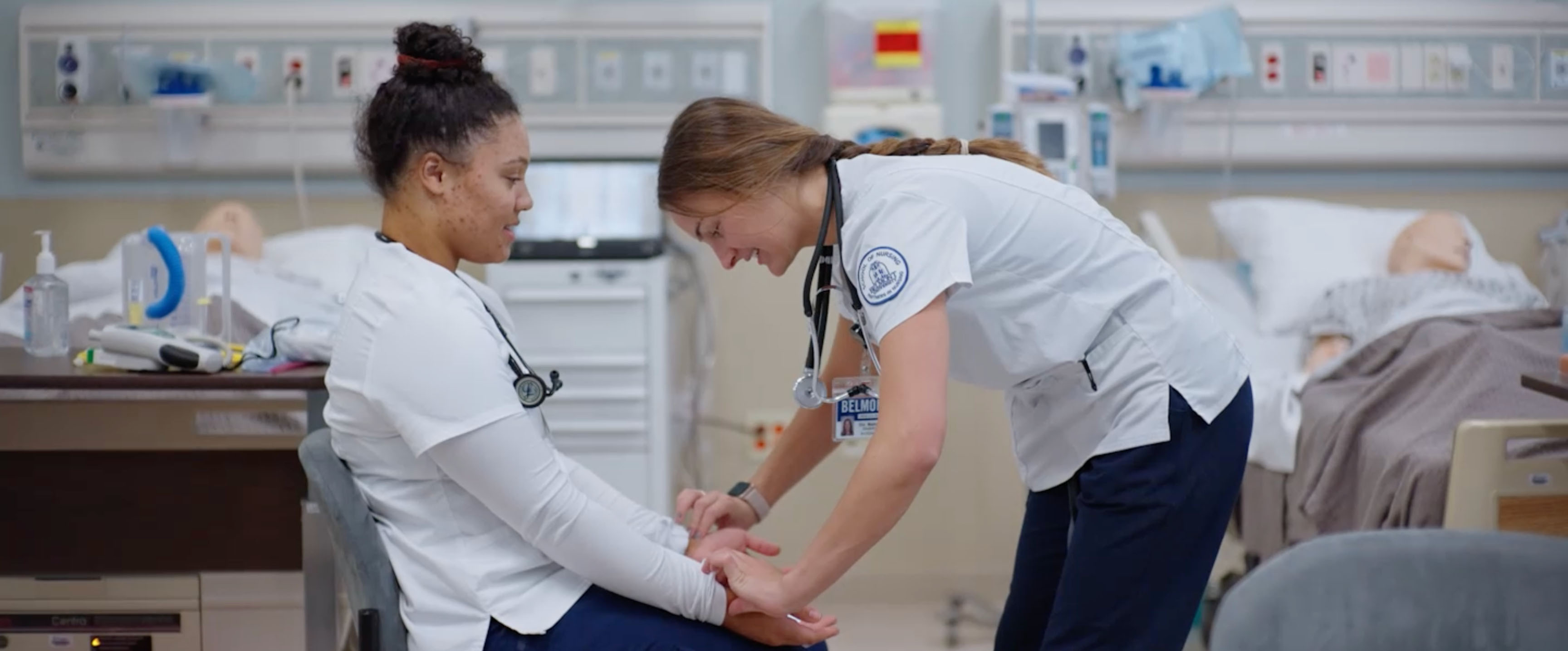 Two nursing students working together in a lab simulation