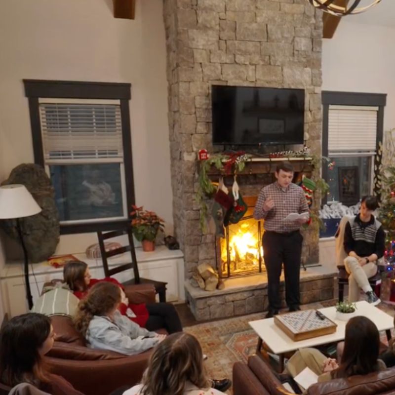 Students in a living room listening to a student read