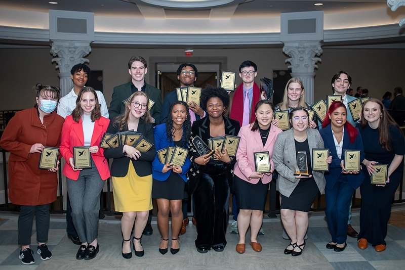 A group of debate students holding awards.