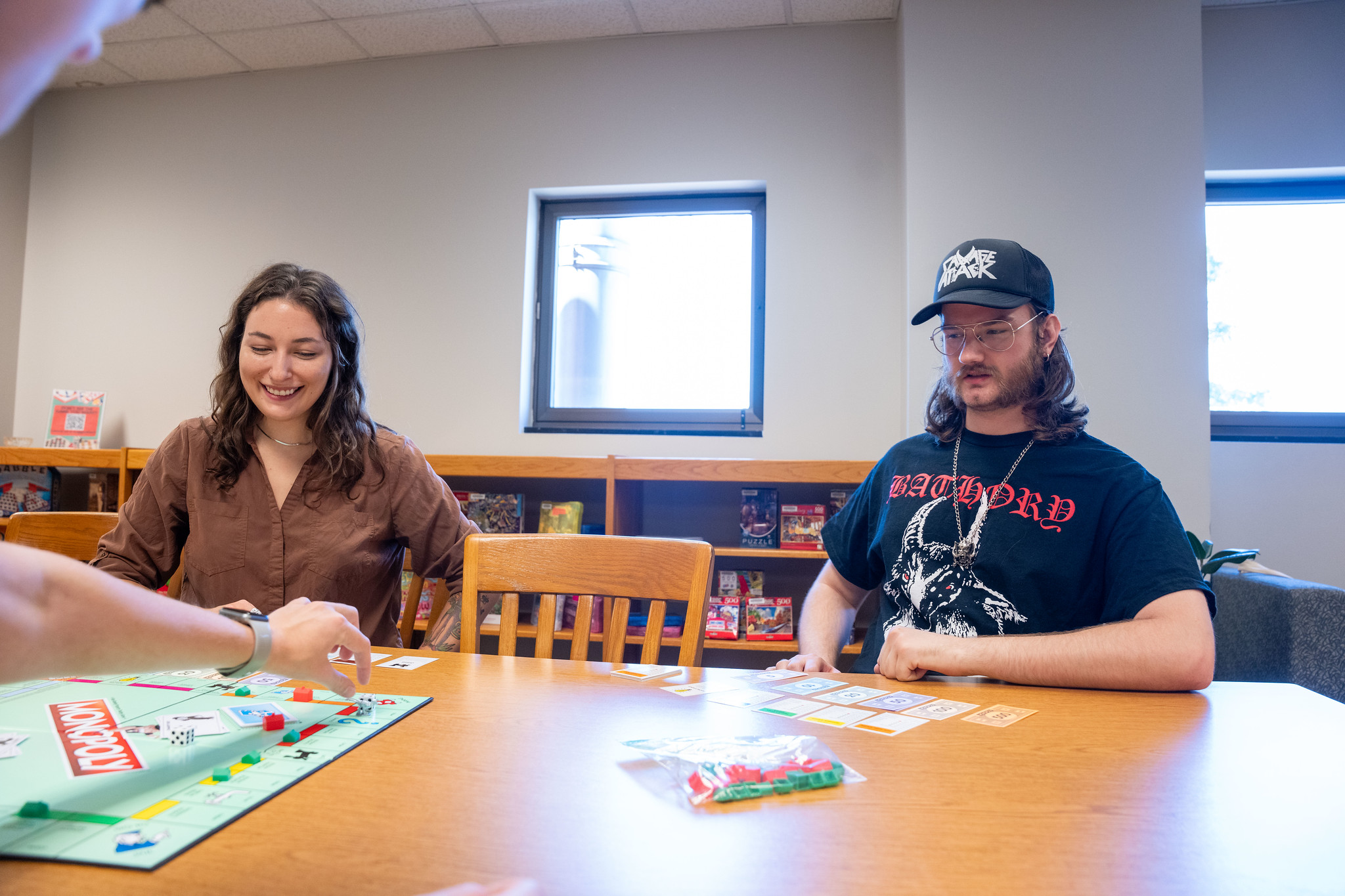 Library visitors smiling and playing Monopoly in Lila's Game Room.