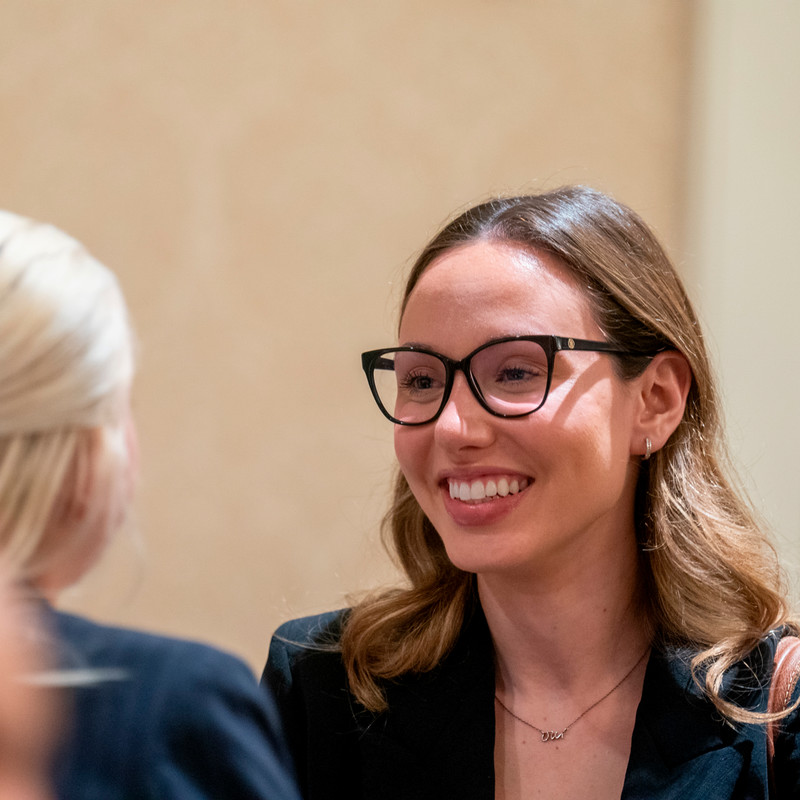 A group of students are engaged in a discussion at a the Massey Mixer. A sign labeled "Finance" is visible. 