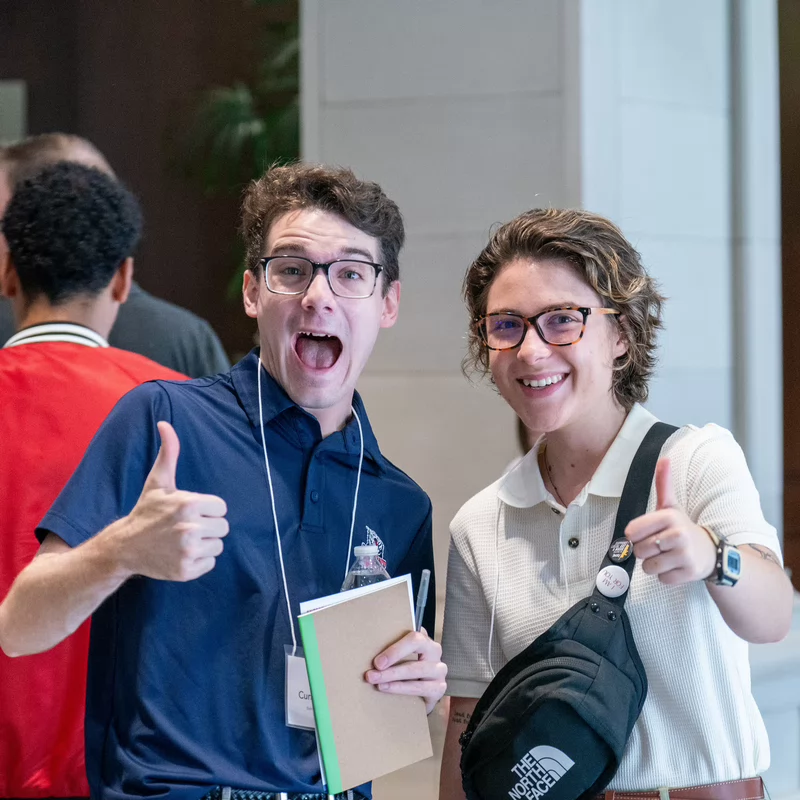 Two Belmont University students smile and give thumbs up while networking at the 24/7: A Mental Health in Entertainment Conference.