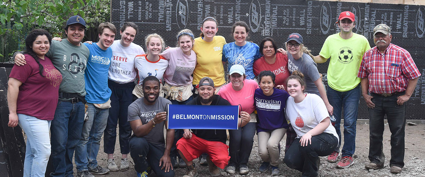 A group of students pose with a sign that says "Belmont on Mission".
