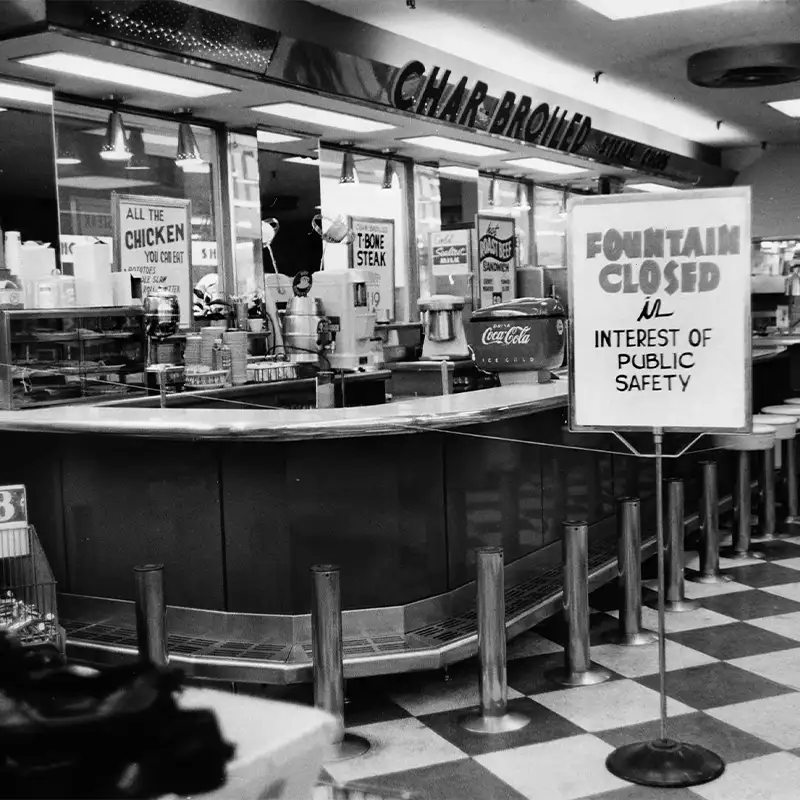 An indoor photo of Walgreen's soda fountain with sign up that reads "Fountain Closed is interest of public safety"