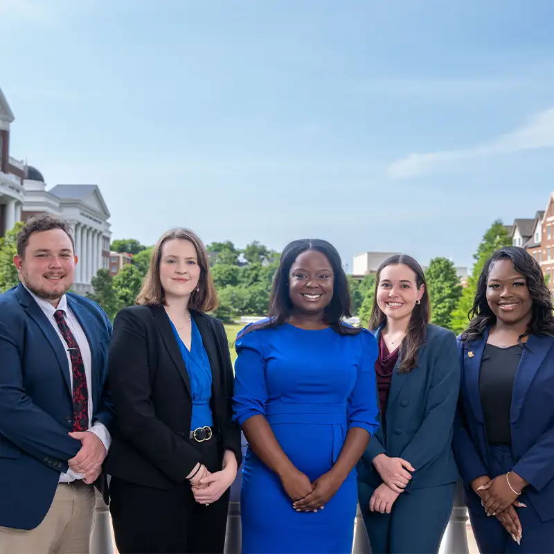 Five fellows pose for a photo together outside in front of a columned porch.