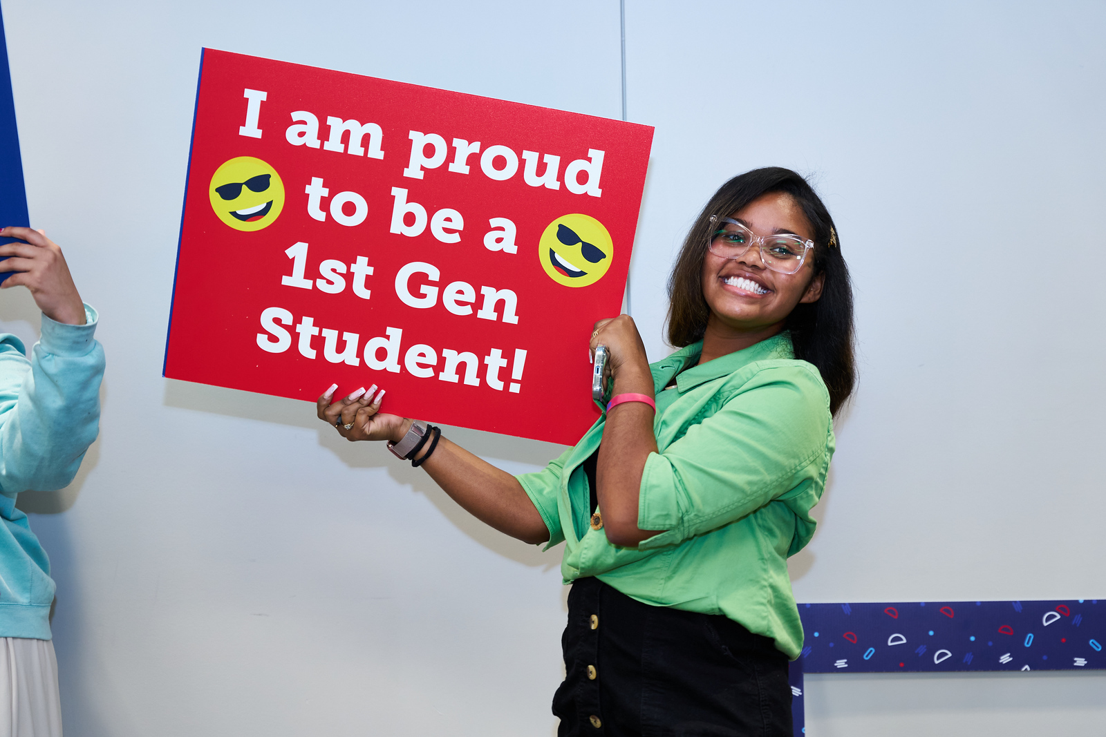 Image of student holding sign that says I am Proud to be a First Gen Students