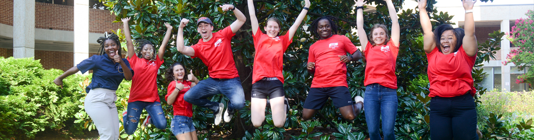 A photo of Resident Advisors wearing matching t-shirts and jumping up in the air together.