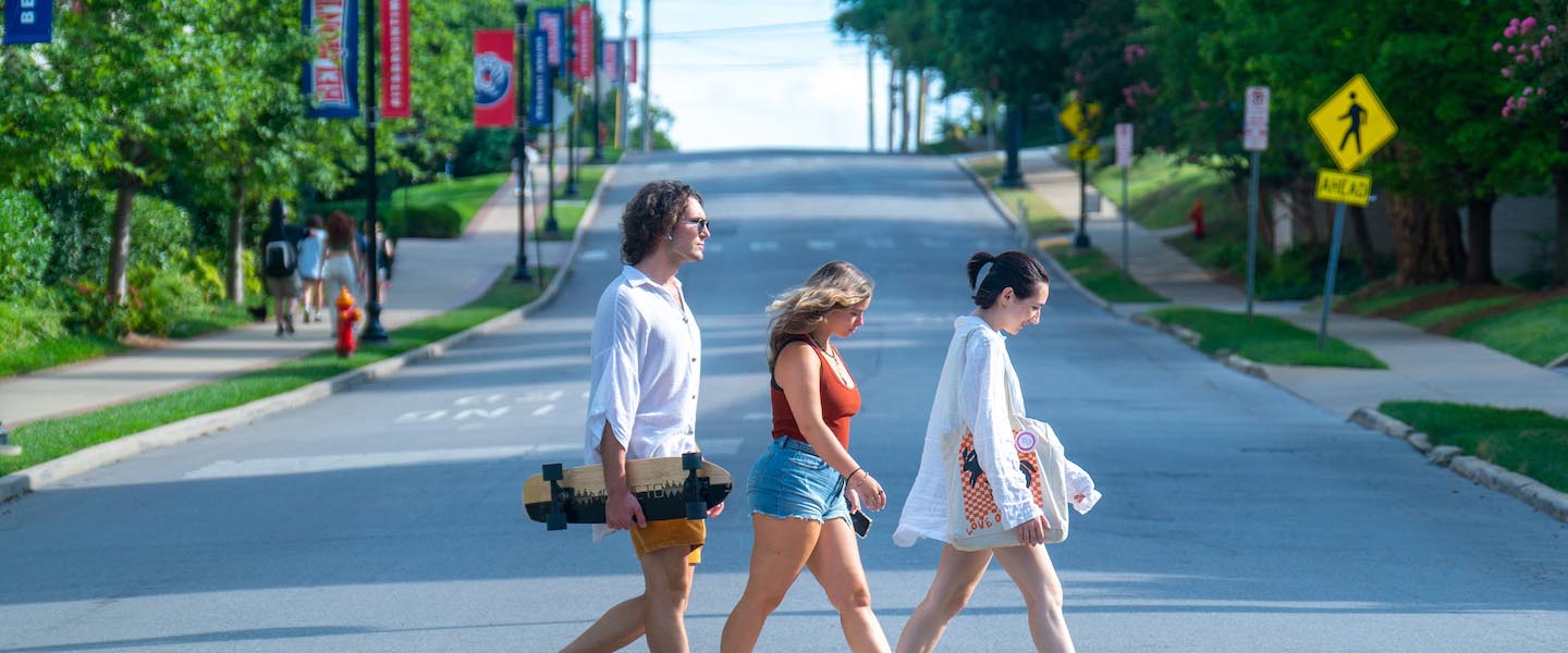 Students walking across street in crosswalk on a sunny day