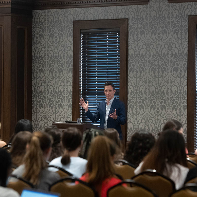 Speaker speaking at conference in room full of people