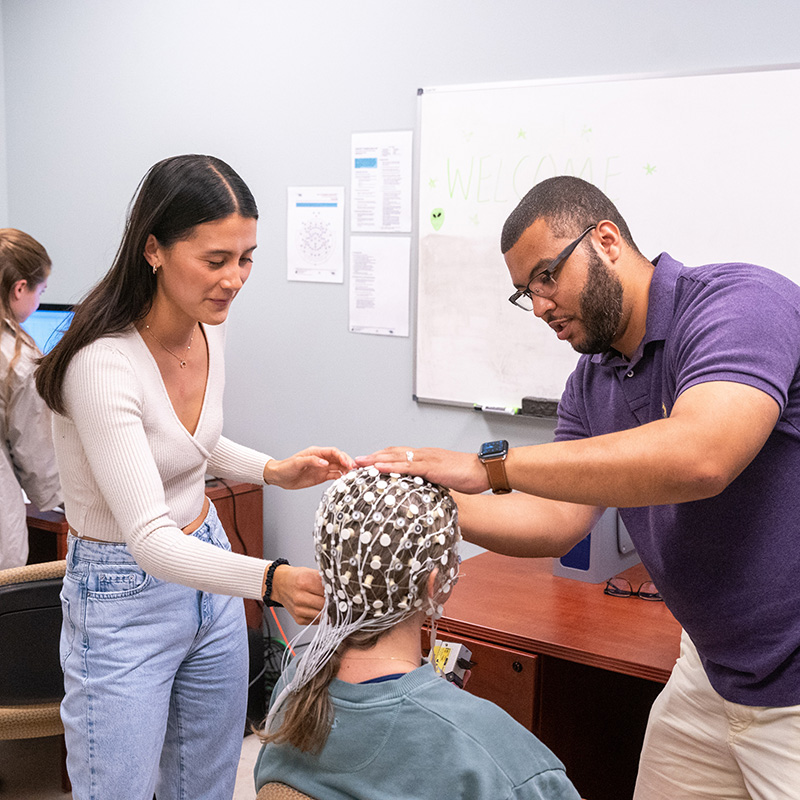 Students and professor working on interactive lab for reading brain waves 