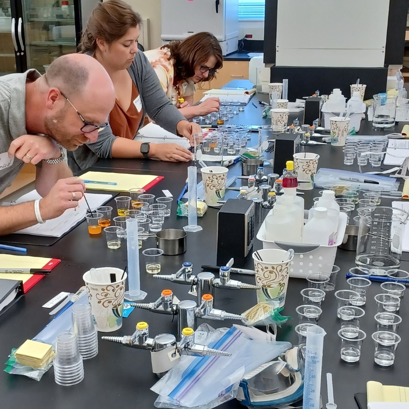 Teachers getting hands-on with chemistry tools at a workshop.