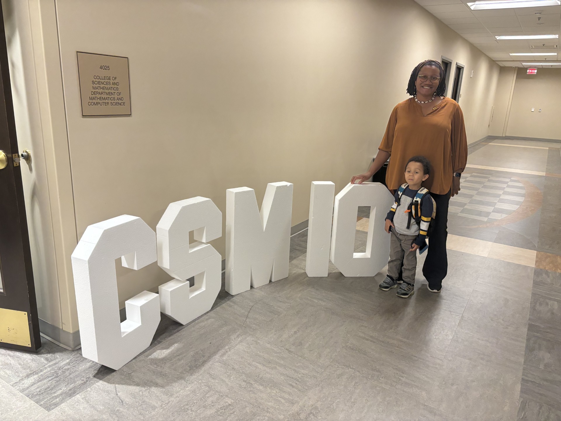 Dr. Beasley and her son with a CSM 10 sign