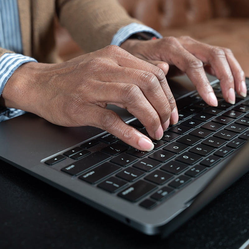 Close up of hands typing on a laptop