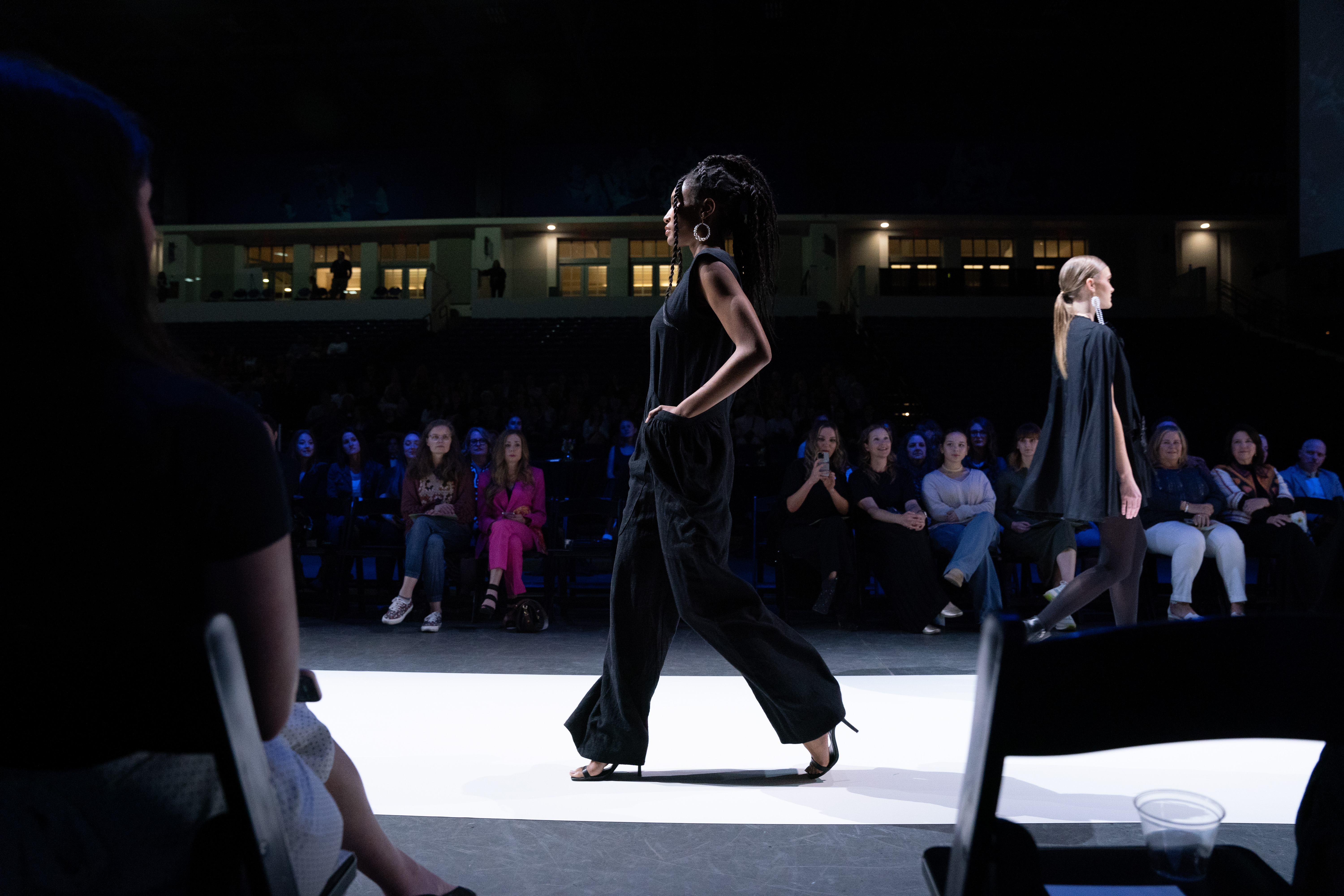 Model walks down runway in sleek black outfit